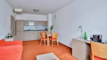 A compact living space with a kitchenette, a dining area, and a seating area.