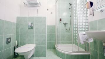 Une salle de bain avec des toilettes, une douche et un lavabo.