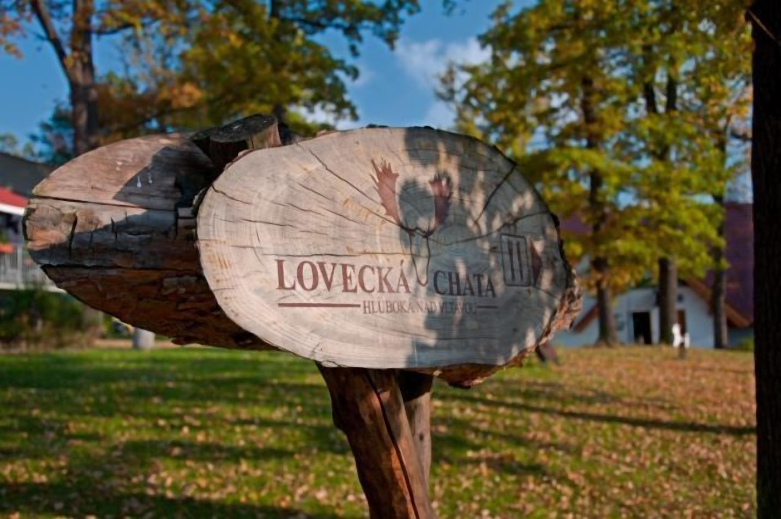 Une enseigne en bois portant les inscriptions « LOVECKA CHATA » et « HUBOKANAD YETIM ».