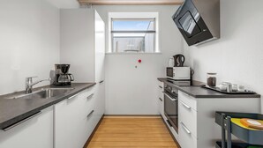 Une cuisine moderne équipée d’un four encastré, d’un four à micro-ondes et d’une machine à café.