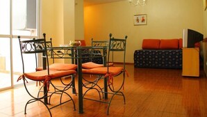 Un espace repas comprenant une table et des chaises, un canapé et un téléviseur.
