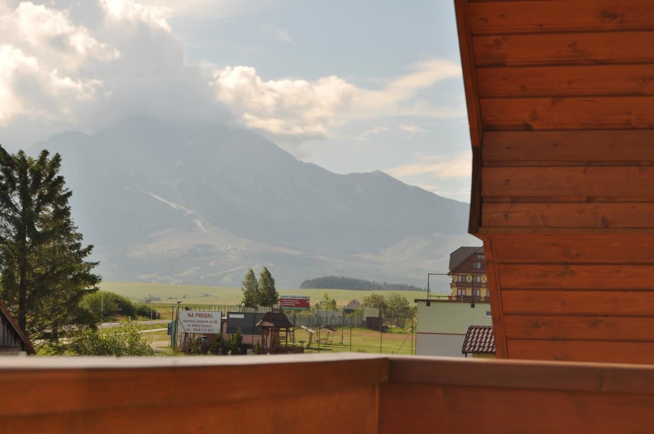 A view of a mountain range with a wooden building in the foreground.