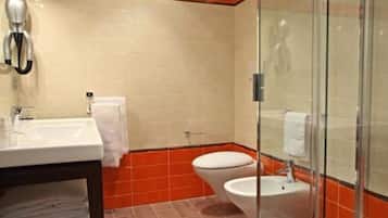 Ein Badezimmer mit einem weißen Waschbecken, einer Toilette und einer Duschkabine aus Glas.