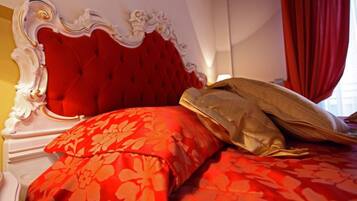 A bed with a red upholstered headboard and floral-patterned bedding.