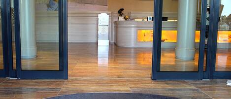 A hotel reception area with a reception desk, a digital screen, and a reception counter.