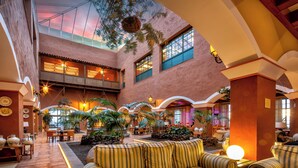 A spacious lobby with a high ceiling, multiple seating areas, and a variety of plants. - Hotel La Palma Princess (Fuencaliente de la Palma)