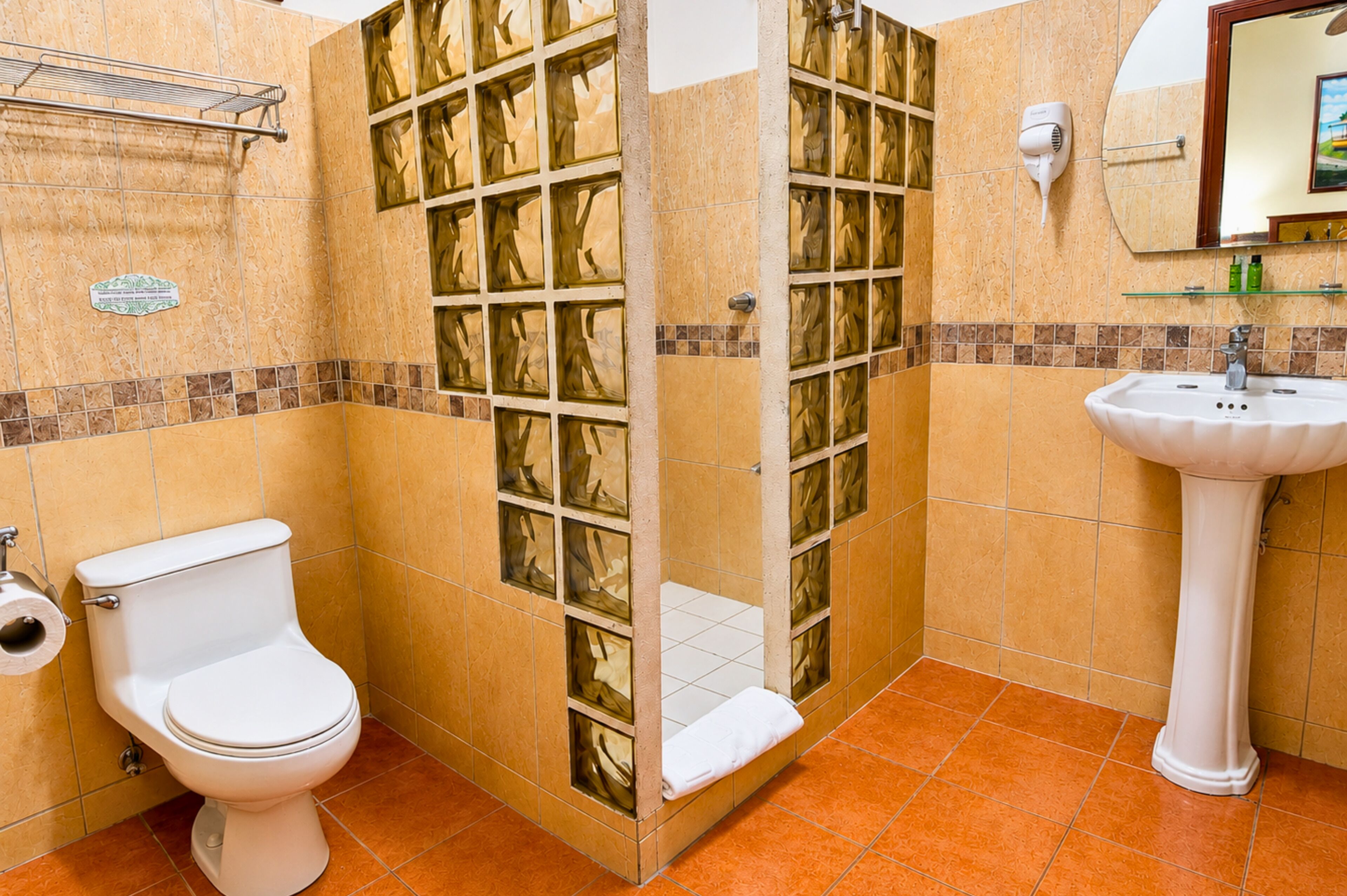 A bathroom with a toilet, a glass-enclosed shower, and a sink.