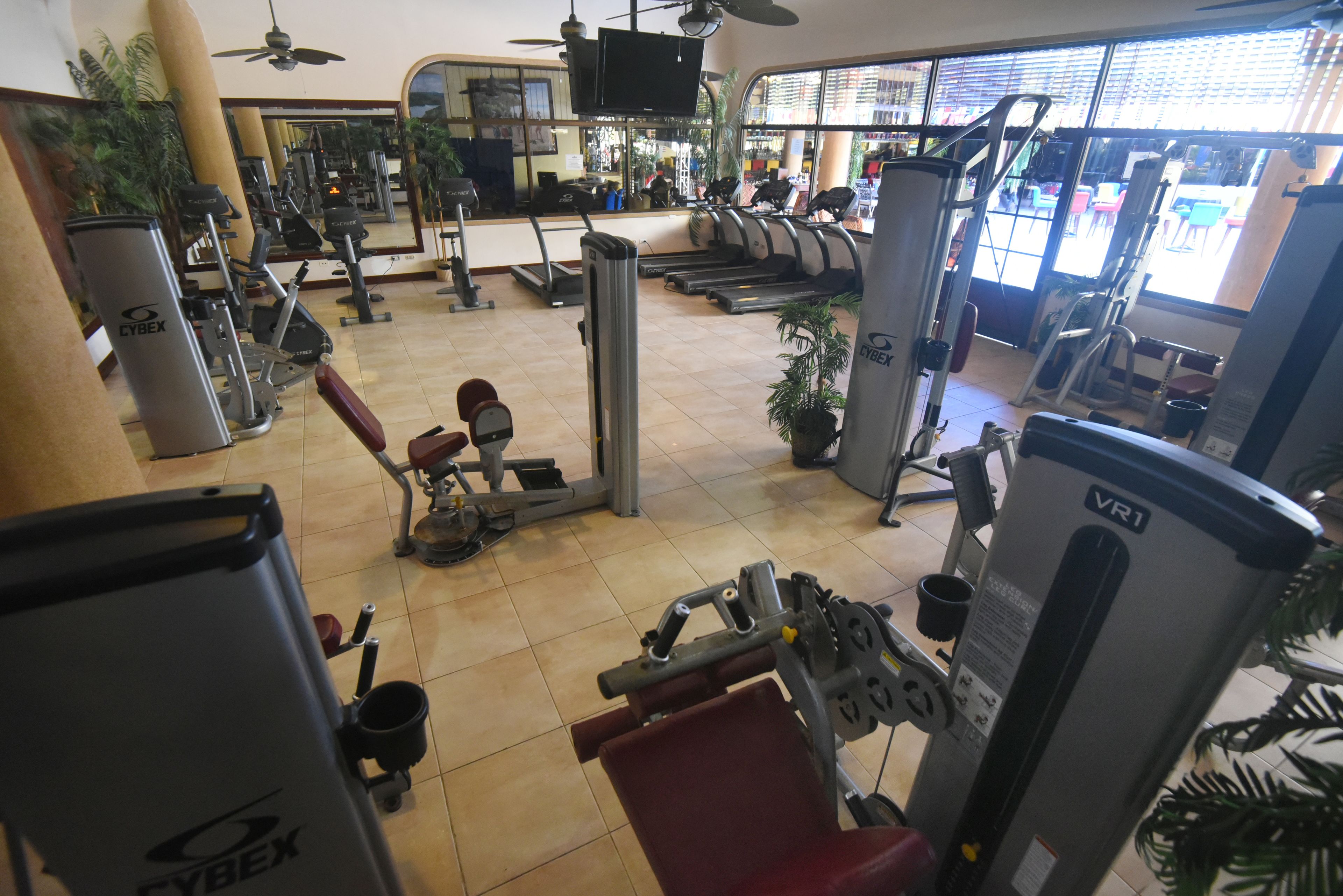 A gym with various exercise equipment, including treadmills, weight machines, and a stationary bike.