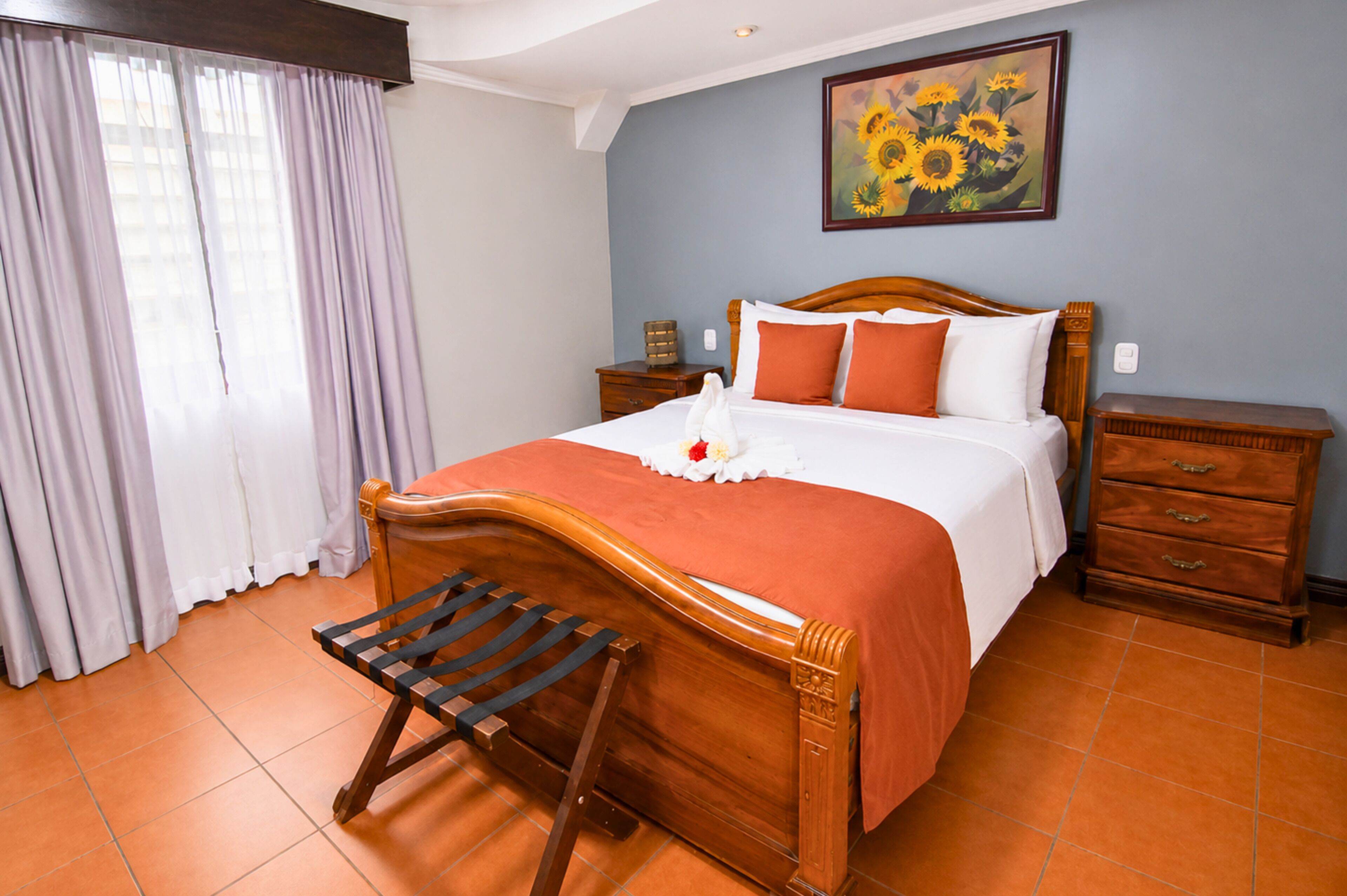 Un dormitorio con una cama de madera, una mesita de noche, un aparador y un cuadro en la pared.