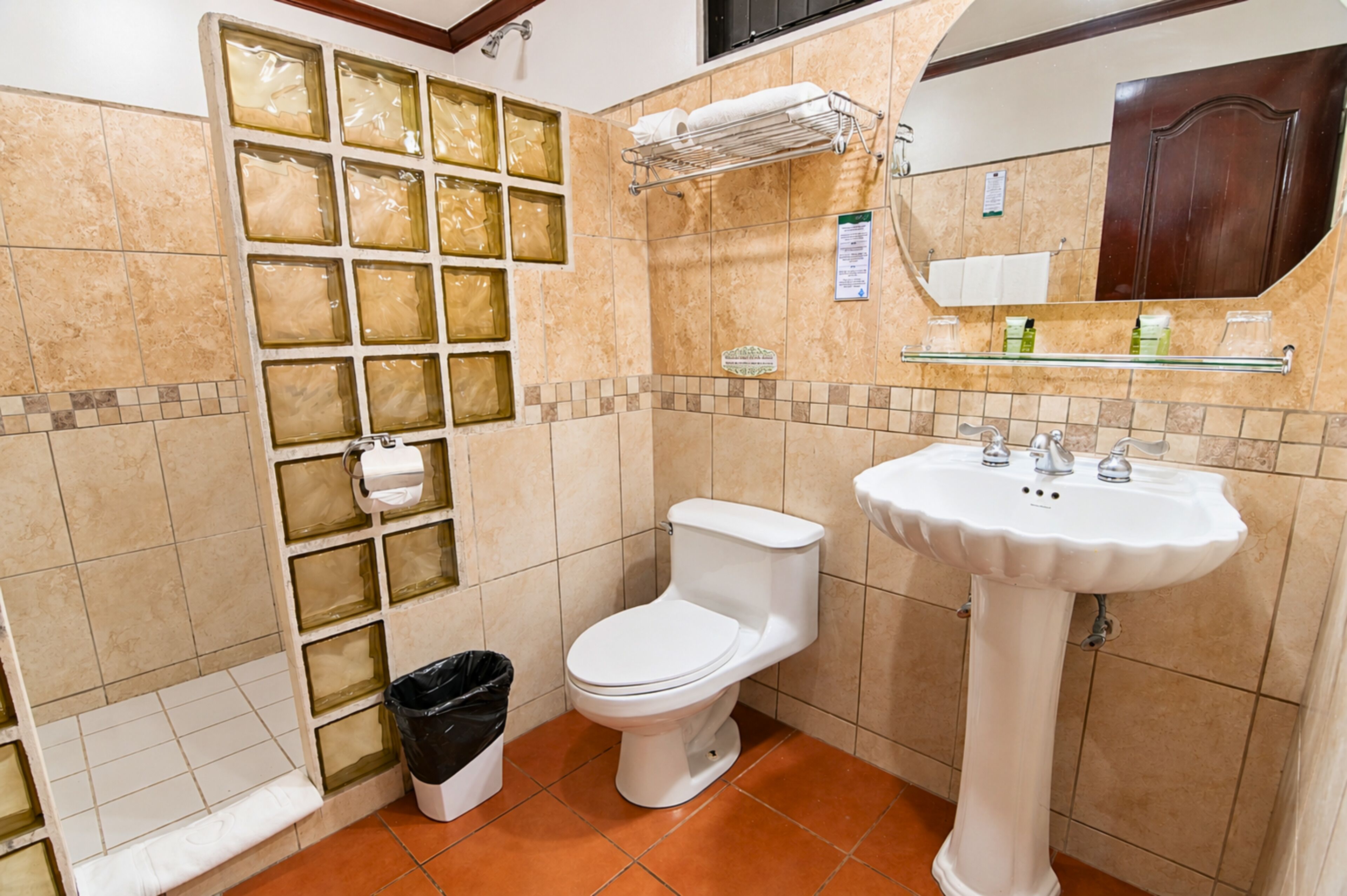 Un baño con inodoro, lavamanos y cabina de ducha de vidrio.