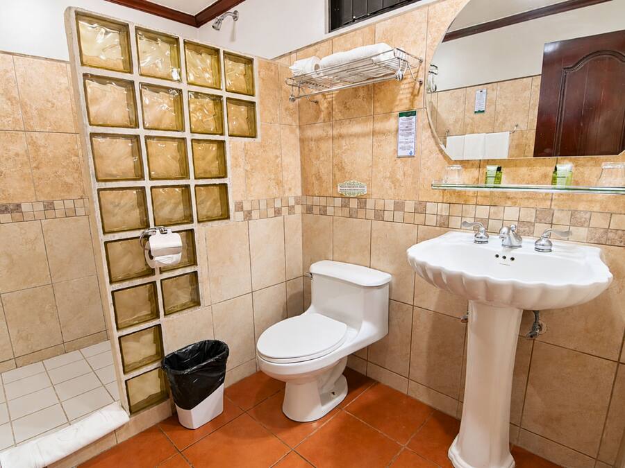 Un baño con inodoro, lavamanos y cabina de ducha de vidrio.
