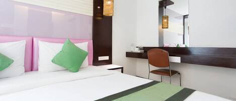 Una camera d'albergo con un letto, una scrivania, una sedia e un grande specchio.