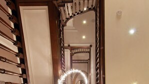 A grand staircase with ornate woodwork and a decorative mirror. - Park Grand Mayfair (London)