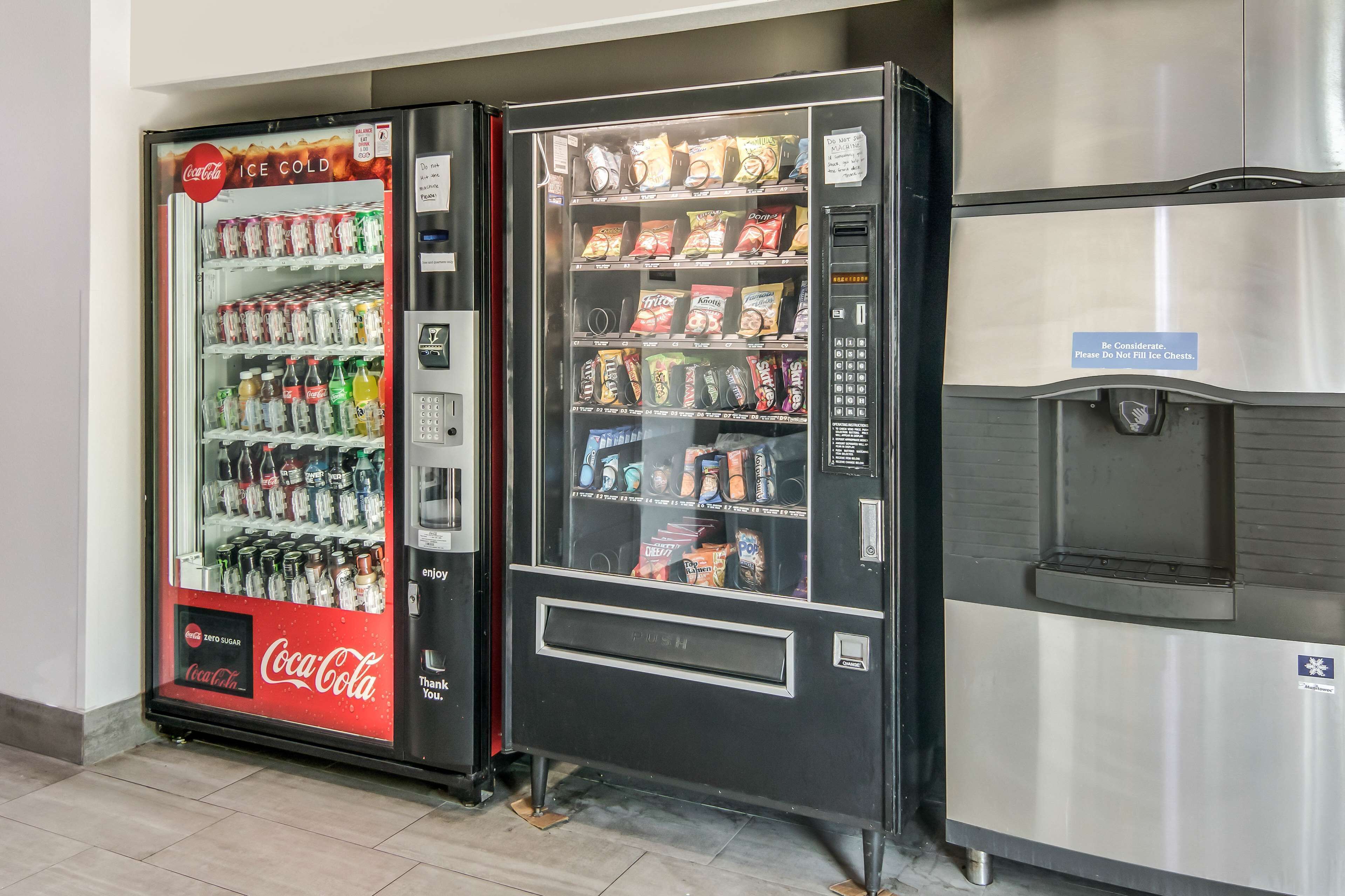 Máquina automática com Coca-Cola e variedade de snacks e bebidas.