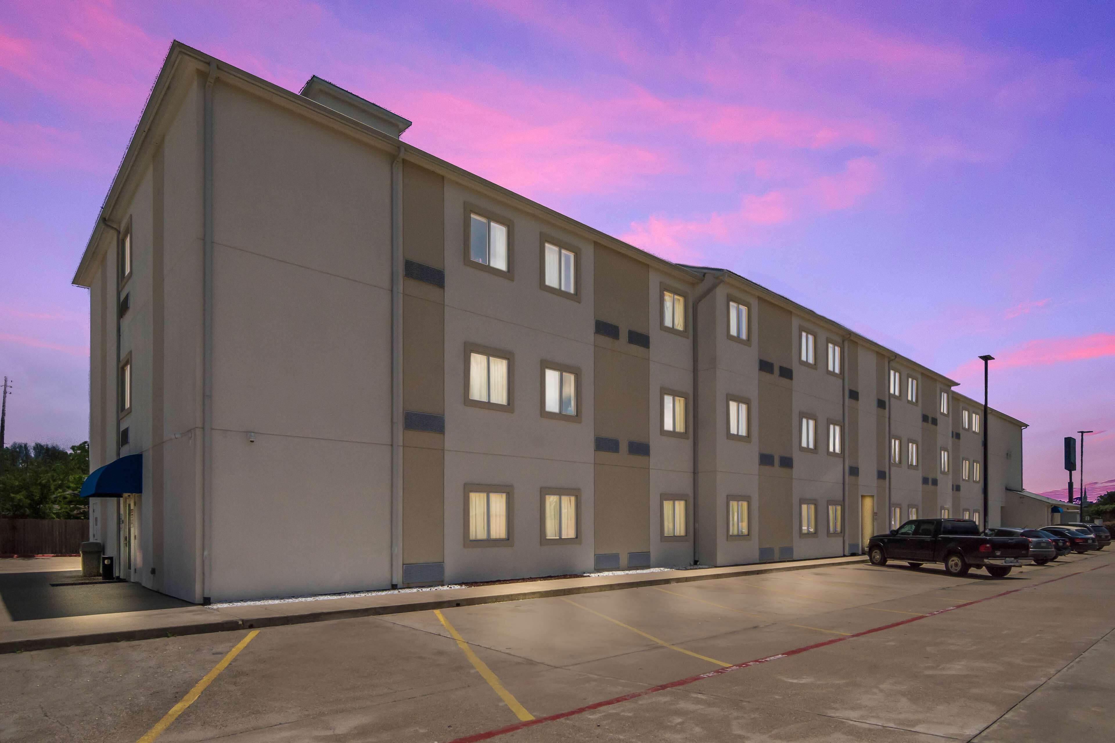 Ein mehrstöckiges Hotel mit Parkplatz.