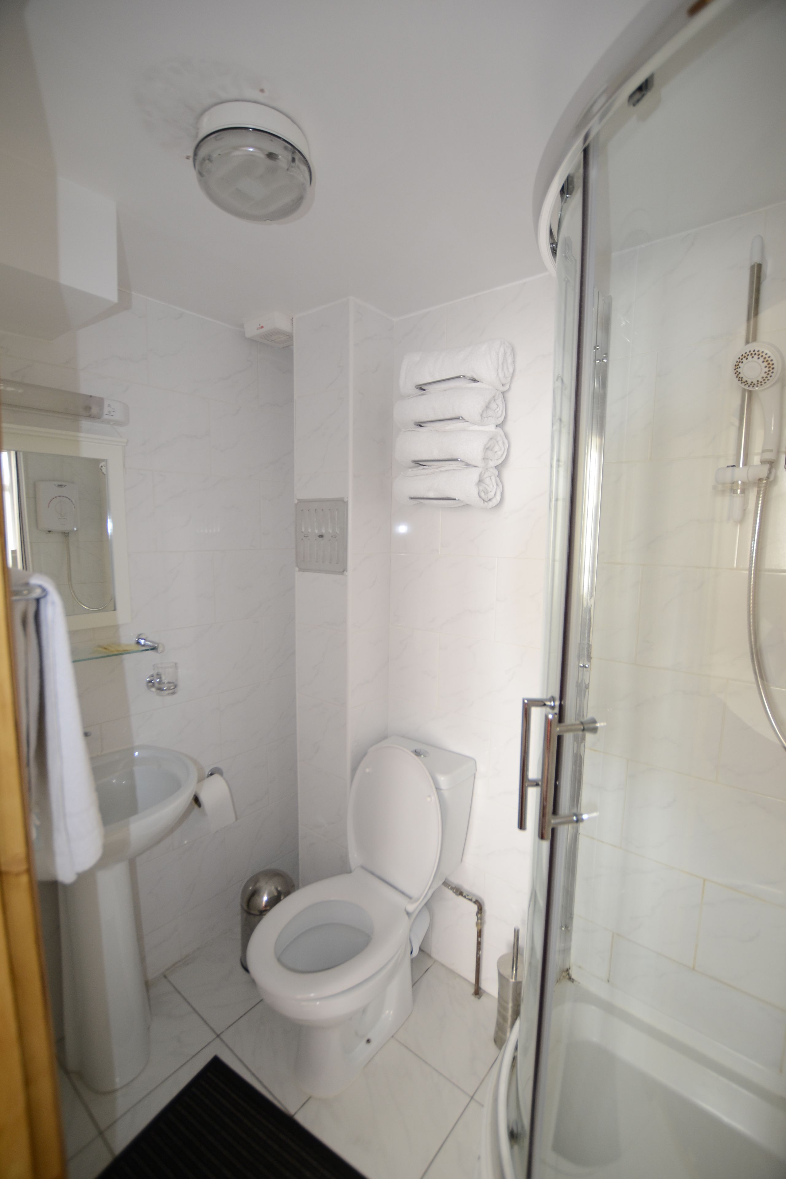 Ein Badezimmer mit Toilette, Waschbecken und einer Duschkabine.