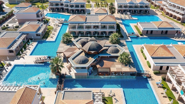 Ein Resort mit mehreren Schwimmbecken, einem zentralen Gebäude mit Kuppel und umliegenden Villen.