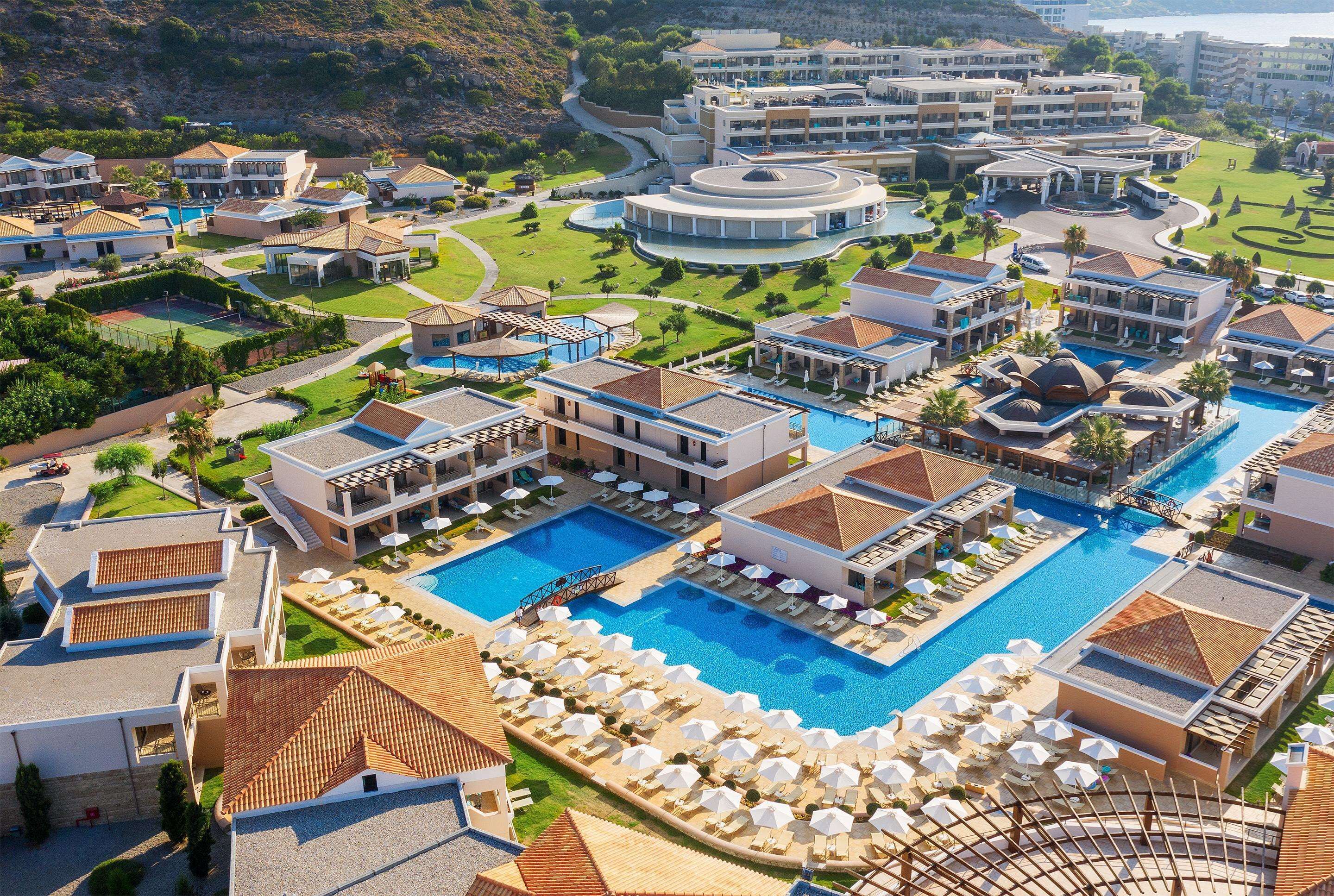 Un resort con varias piscinas, villas y un campo de golf.