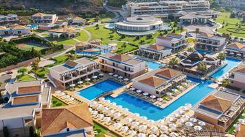 Un resort con varias piscinas, villas y un campo de golf.