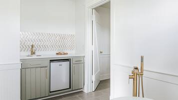 A modern kitchen with a dishwasher, a herringbone-patterned backsplash, and a white countertop.