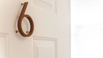 A wooden number '6' sign on a white door.