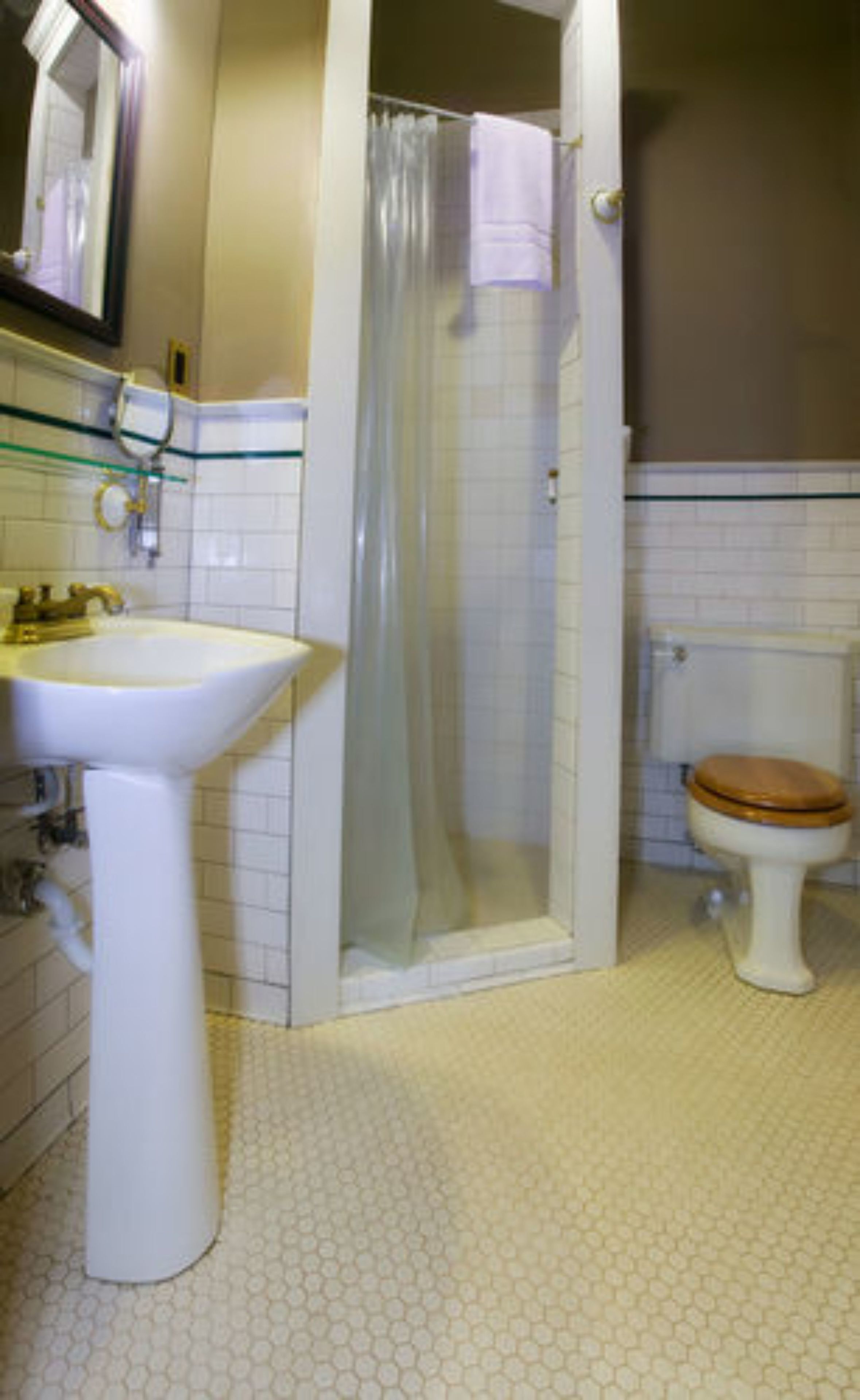 A bathroom with a pedestal sink, a toilet, and a shower enclosure.