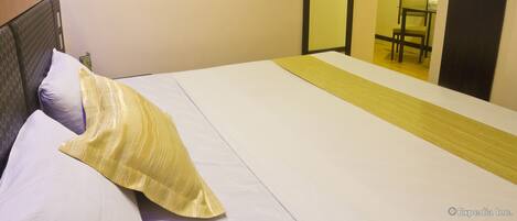 A hotel room with a bed, a television mounted on the wall, and a mirror.