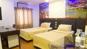 A hotel room with two beds, a desk, and a view of a cityscape. - Eurotel Makati (Makati)