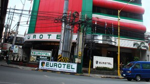 A hotel with a prominent Eurotel sign, multiple floors, and a curved facade. - Eurotel Makati (Makati)
