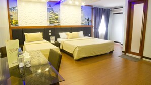 A hotel room with two beds, a table with a menu, and a view of a cityscape through the window. - Eurotel Makati (Makati)