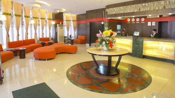 A hotel lobby with orange seating, a reception desk, and a chandelier. - Eurotel Makati (Makati)