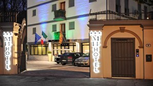 Um hotel com vários andares, sinalização iluminada e varandas.