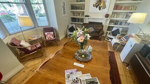 A cozy living room with a wooden coffee table, a fireplace, bookshelves, and comfortable seating.