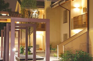 Un edificio moderno con una scala, un recinto in legno e un ingresso ben illuminato.