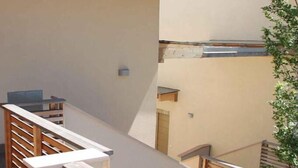 Et moderne interiør med en trappe i træ, et glasbord og en plante.