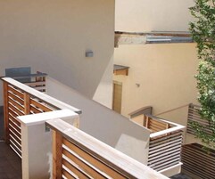 Un interno moderno con una scala in legno, un tavolo in vetro e una pianta.