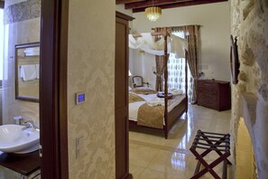 A bedroom with a four-poster bed, a bedside table, a dresser, and a mirror. - Antica Dimora Suites (Rethymno)