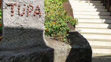 A stone sign with the text "HOTEL TUPA" indicating the name of the establishment.
