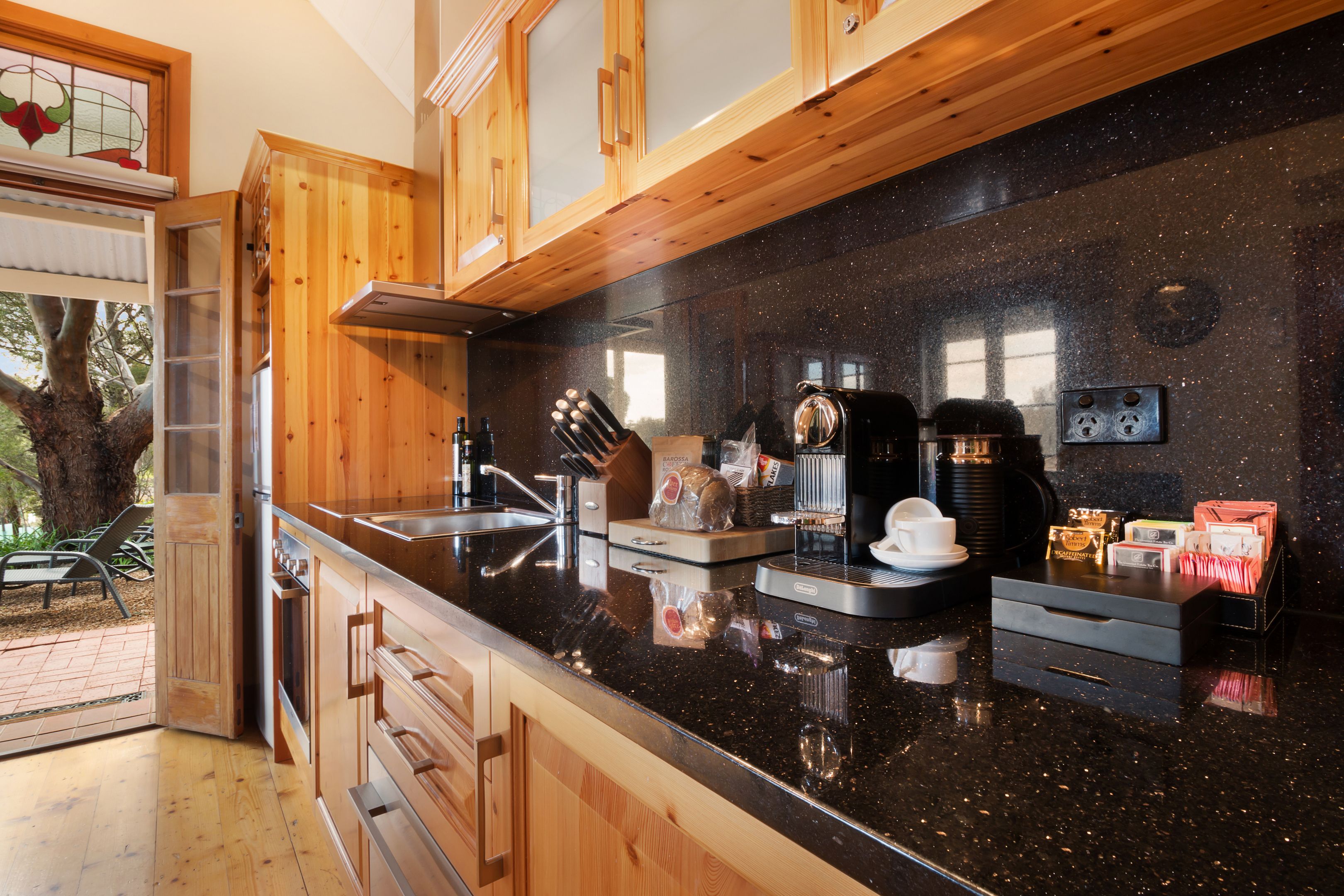A modern kitchen with wooden cabinets, a black granite countertop, and various appliances.