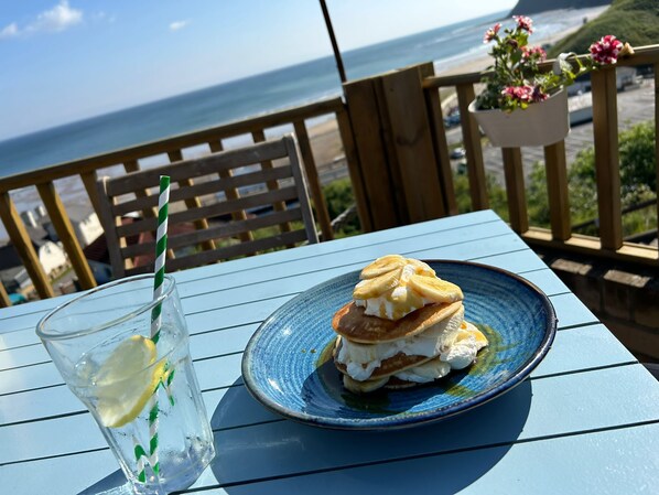 A table with a plate of pancakes and a glass of iced tea with a lemon slice. - The Spa Hotel (Saltburn-by-the-Sea)