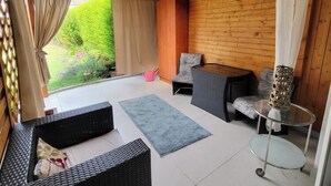 A wooden interior with a sofa, a chair, a small table, and a glass table. - Penzion Janka (Brno)