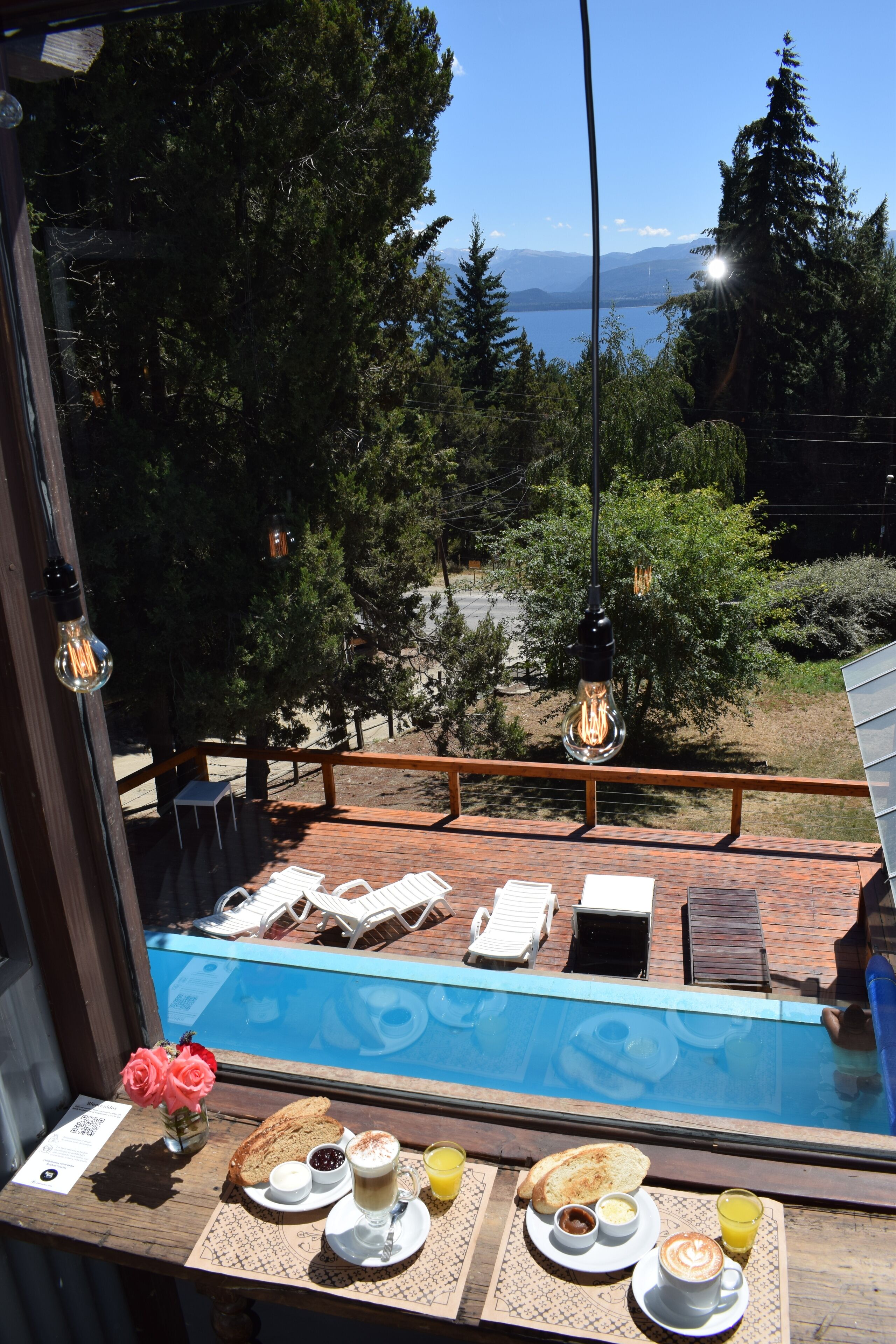 Mesa de desayuno junto a la piscina, con vistas a una piscina y montañas.