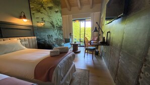 Hotelkamer met een groot bed, een bureau, een stoel en uitzicht op de omgeving.