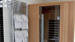 A modern bathroom with a large bathtub, a towel rack, and a glass shower enclosure. - Fletcher Hotel Marijke (Bergen)