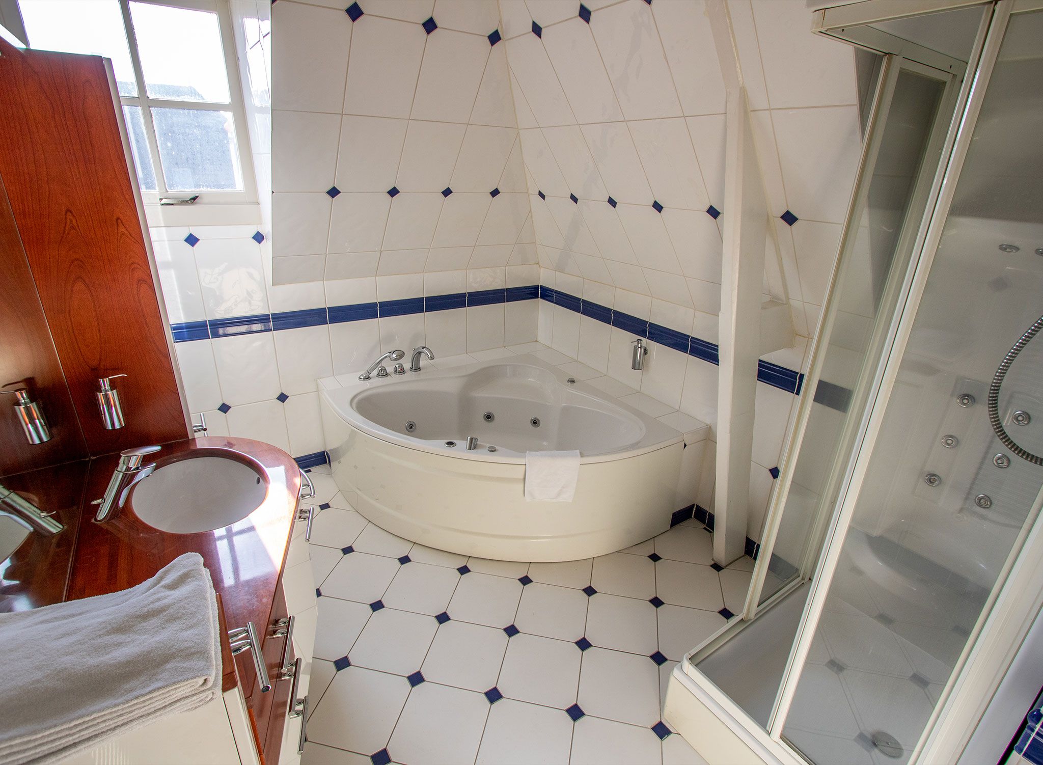 A bathroom with a bathtub, a shower, and a vanity with a sink.