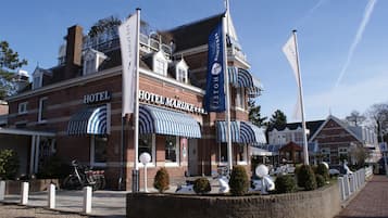 Classic hotel with a symmetrical design and central entrance, featuring a driveway and landscaped area.