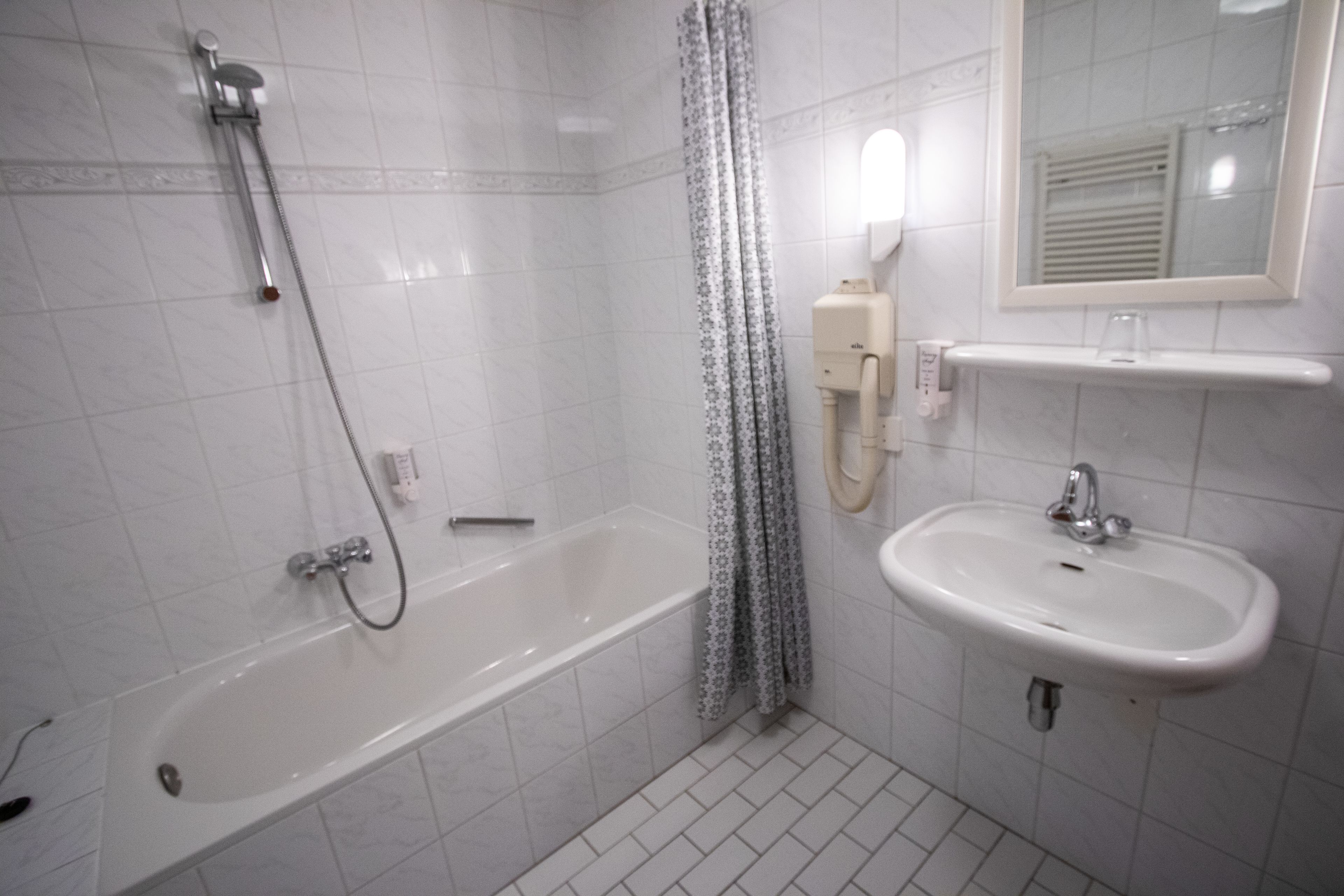 Ein Badezimmer mit einer Badewanne, einem Waschbecken und einer Dusche.