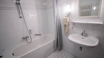 Ein Badezimmer mit einer Badewanne, einem Waschbecken und einer Dusche.