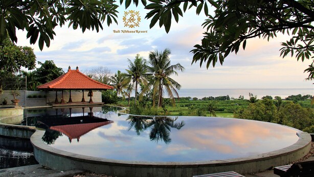 A resort with a large infinity pool, a gazebo, and a view of the ocean. - Bali Nibbana Resort (Seririt)