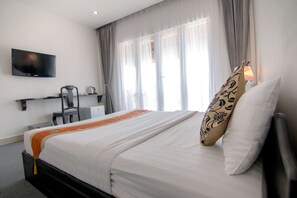 A hotel room with a bed, a TV, a desk with a chair, and a window with curtains. - Diamond Palace Hotel (Phnom Penh)